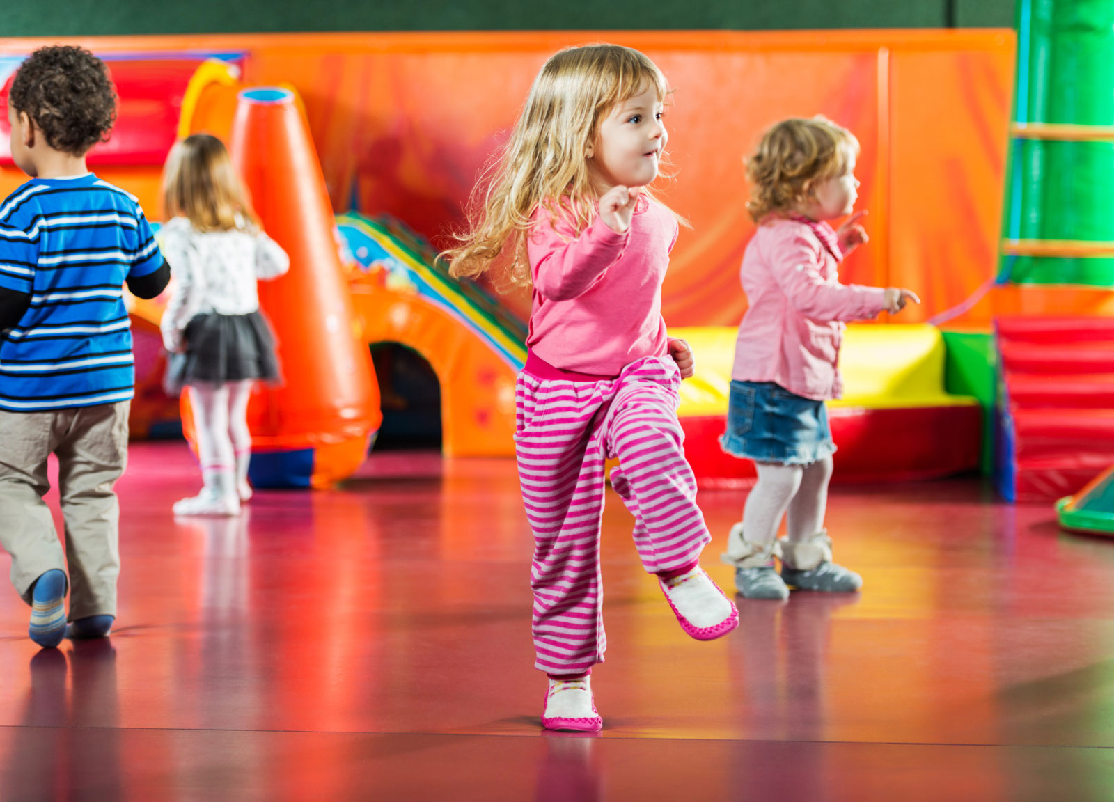 Kleine Kinder tanzen in einem bunten Bewegungsraum