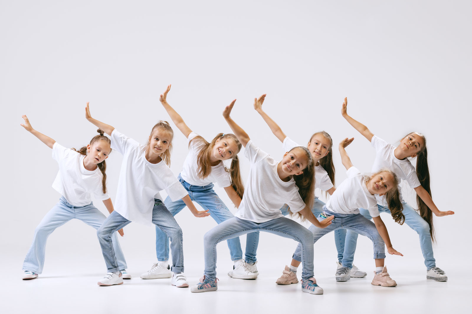 Kinder in weißen Shirts tanzen eine Choreografie